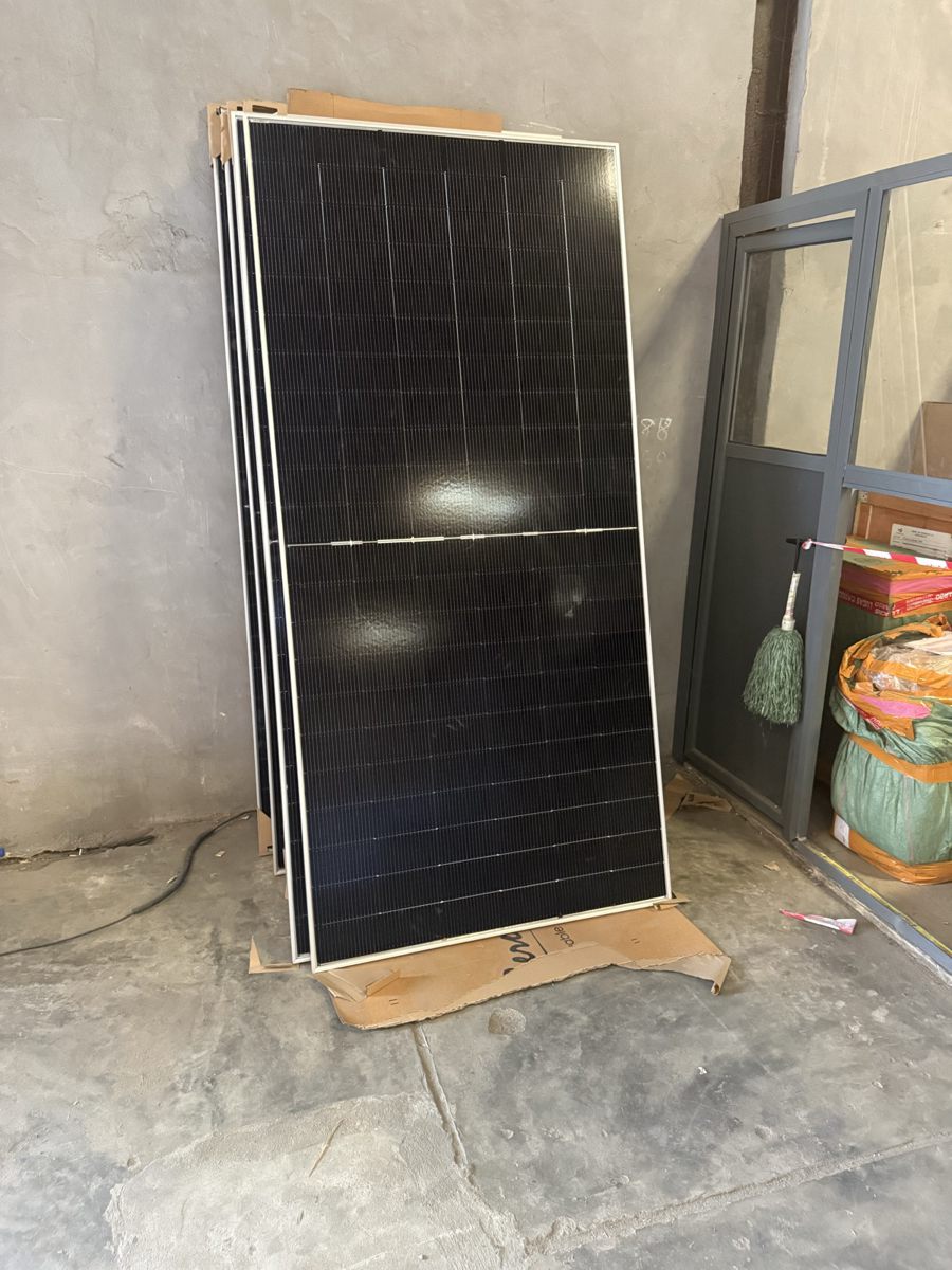 Unboxed Jinko Tiger Neo 620W bifacial solar panels stacked in a Lagos warehouse